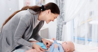 Mum changing reusable nappy on baby